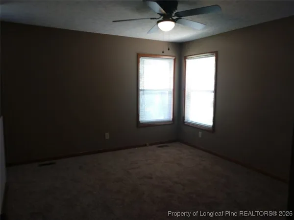 an empty room with closet and a chandelier fan