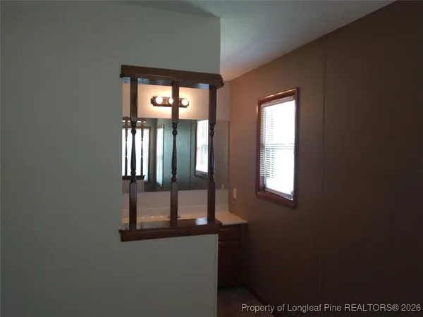 a bathroom with a granite countertop bathtub shower sink mirror and toilet