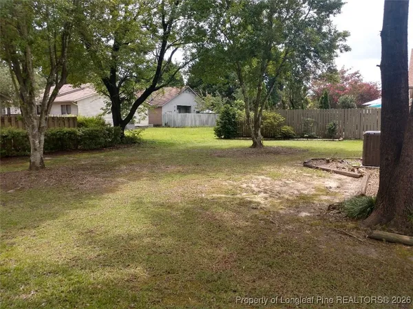 a backyard of a house with trampoline and trees