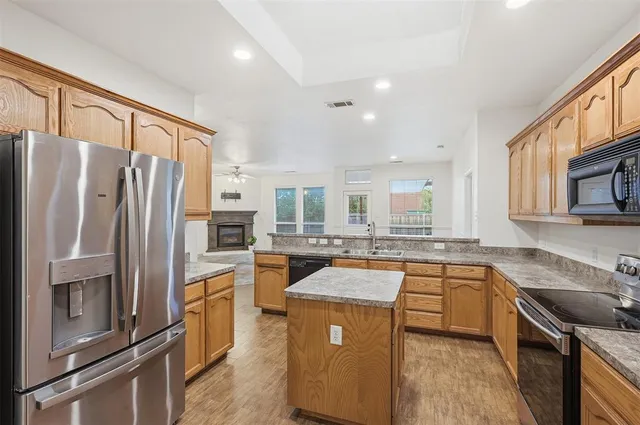 a kitchen with stainless steel appliances granite countertop a refrigerator stove microwave and sink