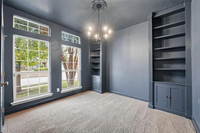 a view of empty room with windows and cabinet