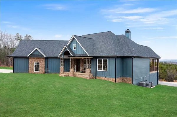 a view of a house with a yard and sitting area