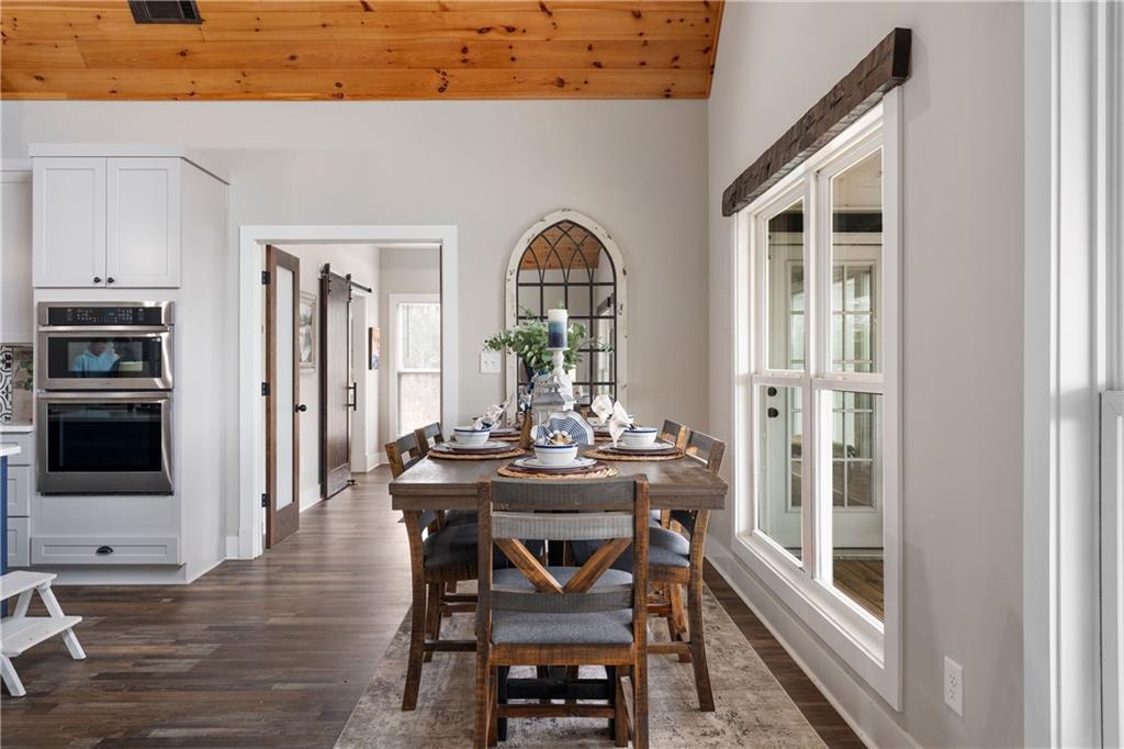 610 Cedar Creek Road Cartersville, GA 30121 - Photo 34 of 75 a dining room with furniture a floor to ceiling window and wooden floor