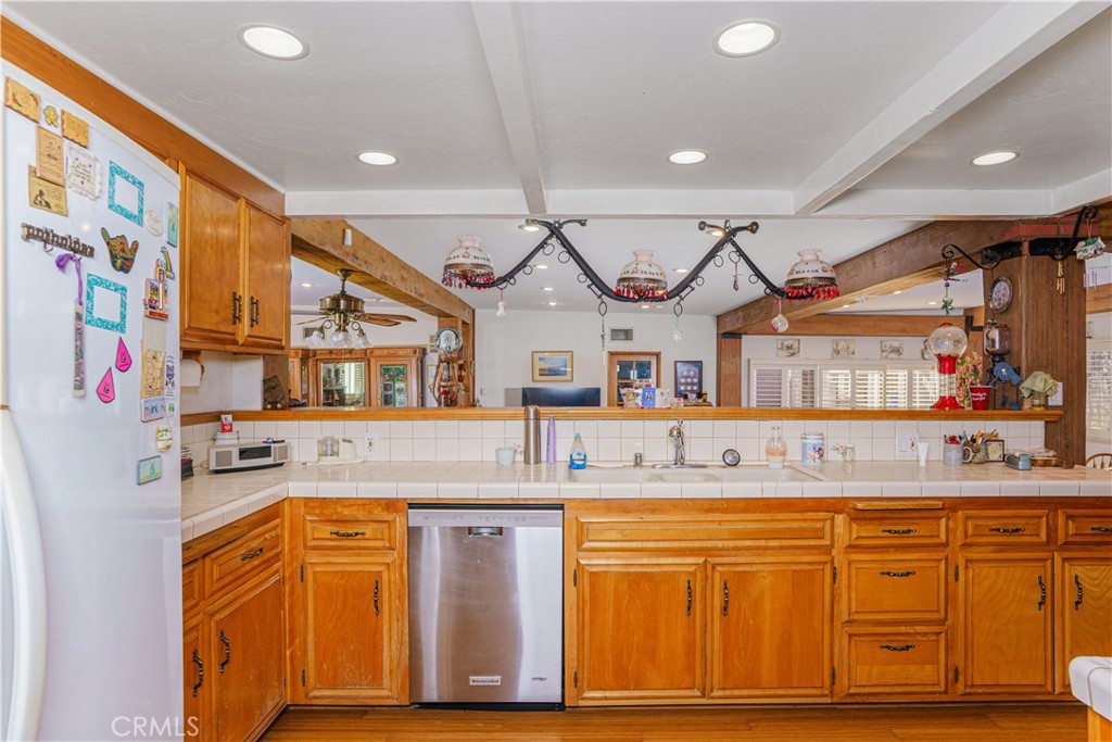 150 Pinal Avenue Santa Maria, CA 93455 - Photo 17 of 36 a kitchen with stainless steel appliances granite countertop a sink and cabinets with wooden floor