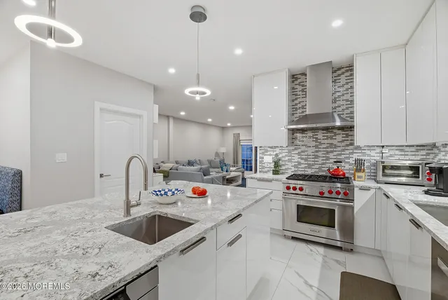 a kitchen with stainless steel appliances granite countertop a sink a stove and a refrigerator