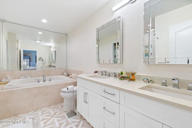 a bathroom with a tub sink and mirror