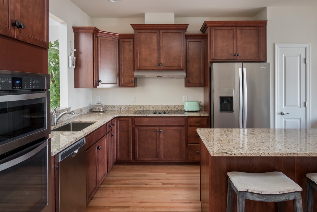 81 Monroe Drive, Unit 16 Holliston, MA 01746 - Photo 17 of 30 a kitchen with stainless steel appliances granite countertop wooden cabinets a stove a sink and dishwasher