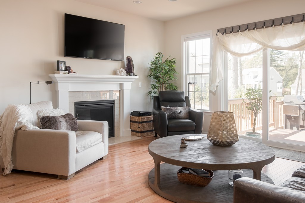 81 Monroe Drive, Unit 16 Holliston, MA 01746 - Photo 19 of 30 a living room with furniture a flat screen tv and a fireplace