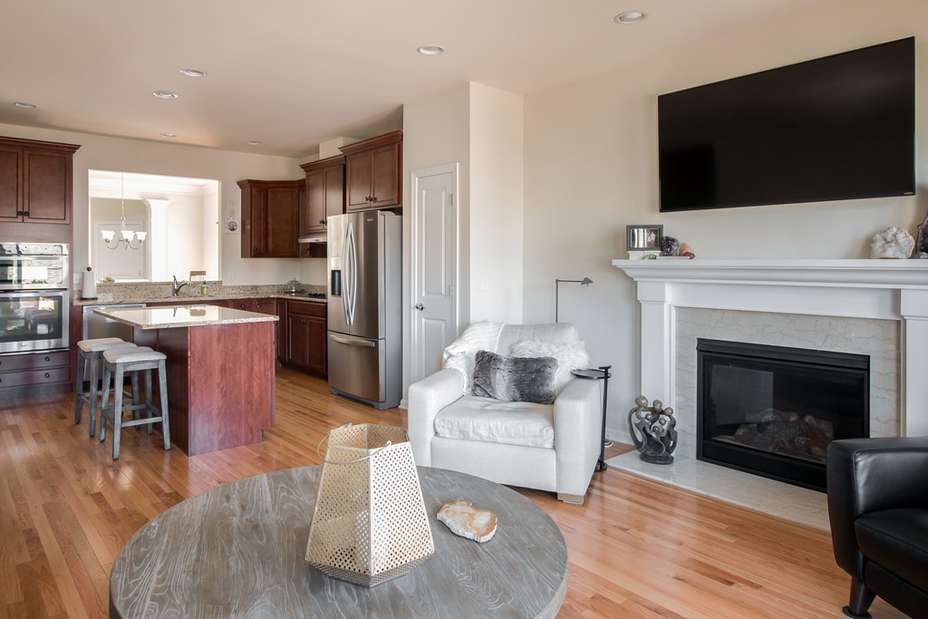 81 Monroe Drive, Unit 16 Holliston, MA 01746 - Photo 21 of 30 a living room with stainless steel appliances furniture a fireplace a flat screen tv and kitchen view