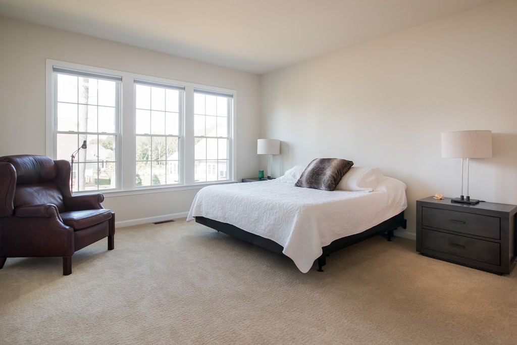 81 Monroe Drive, Unit 16 Holliston, MA 01746 - Photo 22 of 30 a bedroom with a bed and a couch