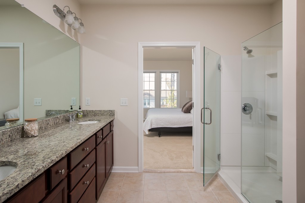 81 Monroe Drive, Unit 16 Holliston, MA 01746 - Photo 23 of 30 a en suite bathroom with a granite countertop sink and a mirror