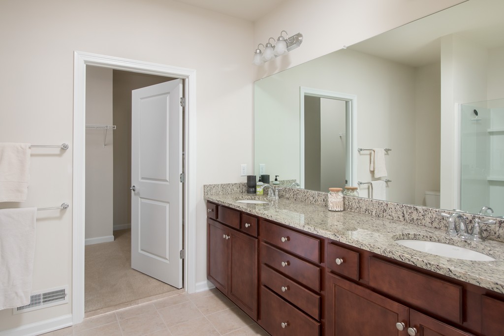 81 Monroe Drive, Unit 16 Holliston, MA 01746 - Photo 24 of 30 a bathroom with a granite countertop sink double and mirror