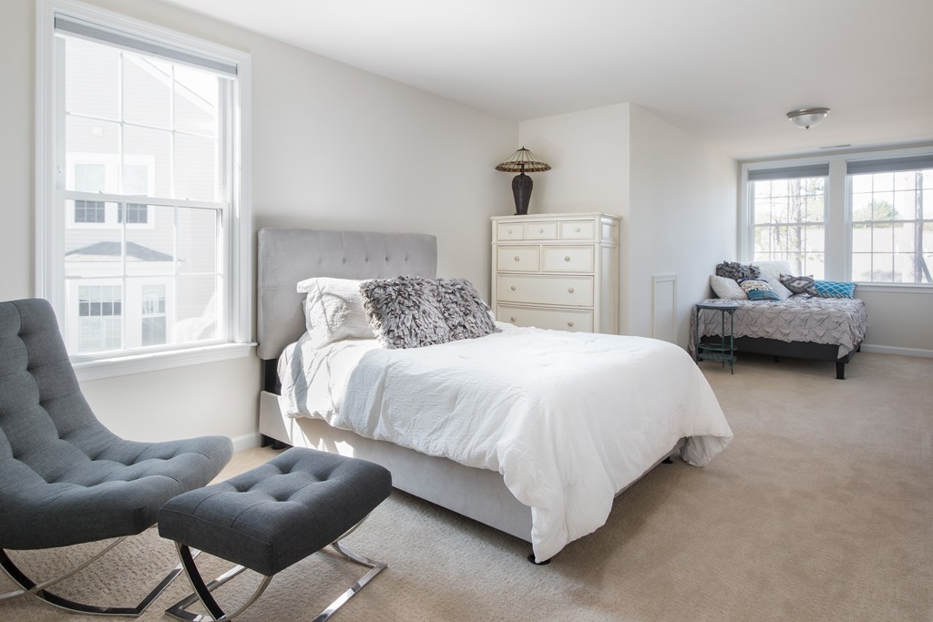 81 Monroe Drive, Unit 16 Holliston, MA 01746 - Photo 29 of 30 a bedroom with a bed and a couch