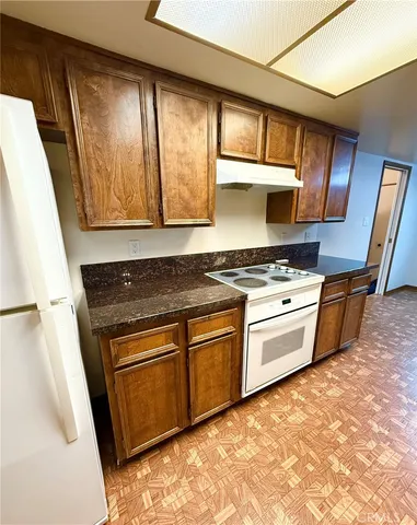 a kitchen with granite countertop stainless steel appliances and wooden cabinets