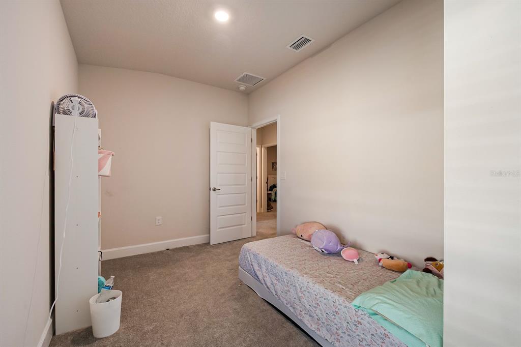 3711 Sagefield Drive Harmony, FL 34773 - Photo 7 of 24 a bedroom with a bed and a potted plant