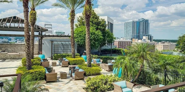 a view of a patio with couches table and chairs and potted plants