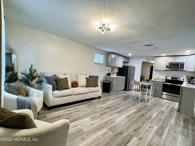 a living room with furniture and kitchen