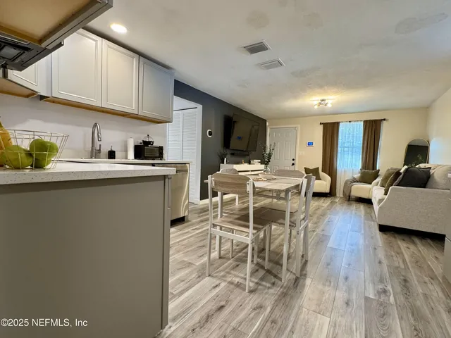 a living room with furniture a wooden floor and a sink