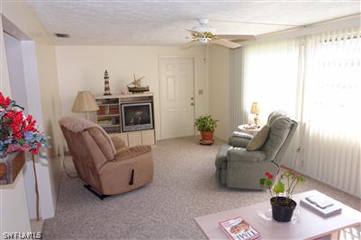 5808 Sailfish Road Bokeelia, FL 33922 - Photo 3 of 9 a living room with furniture and a chandelier