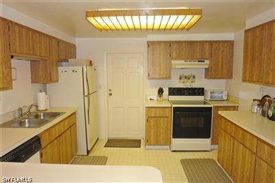 5808 Sailfish Road Bokeelia, FL 33922 - Photo 6 of 9 a kitchen with stainless steel appliances a stove a sink and a refrigerator