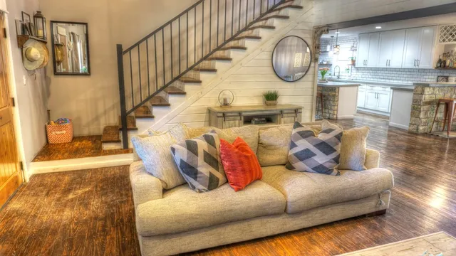 a kitchen with stainless steel appliances granite countertop a refrigerator a sink a stove and a wooden floors