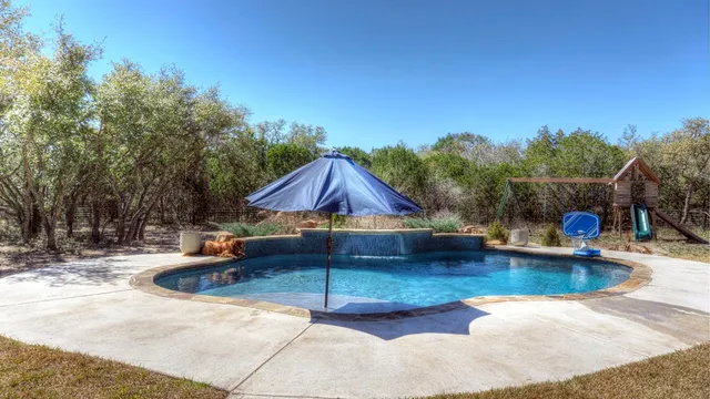 a view of a swimming pool with a patio and a garden