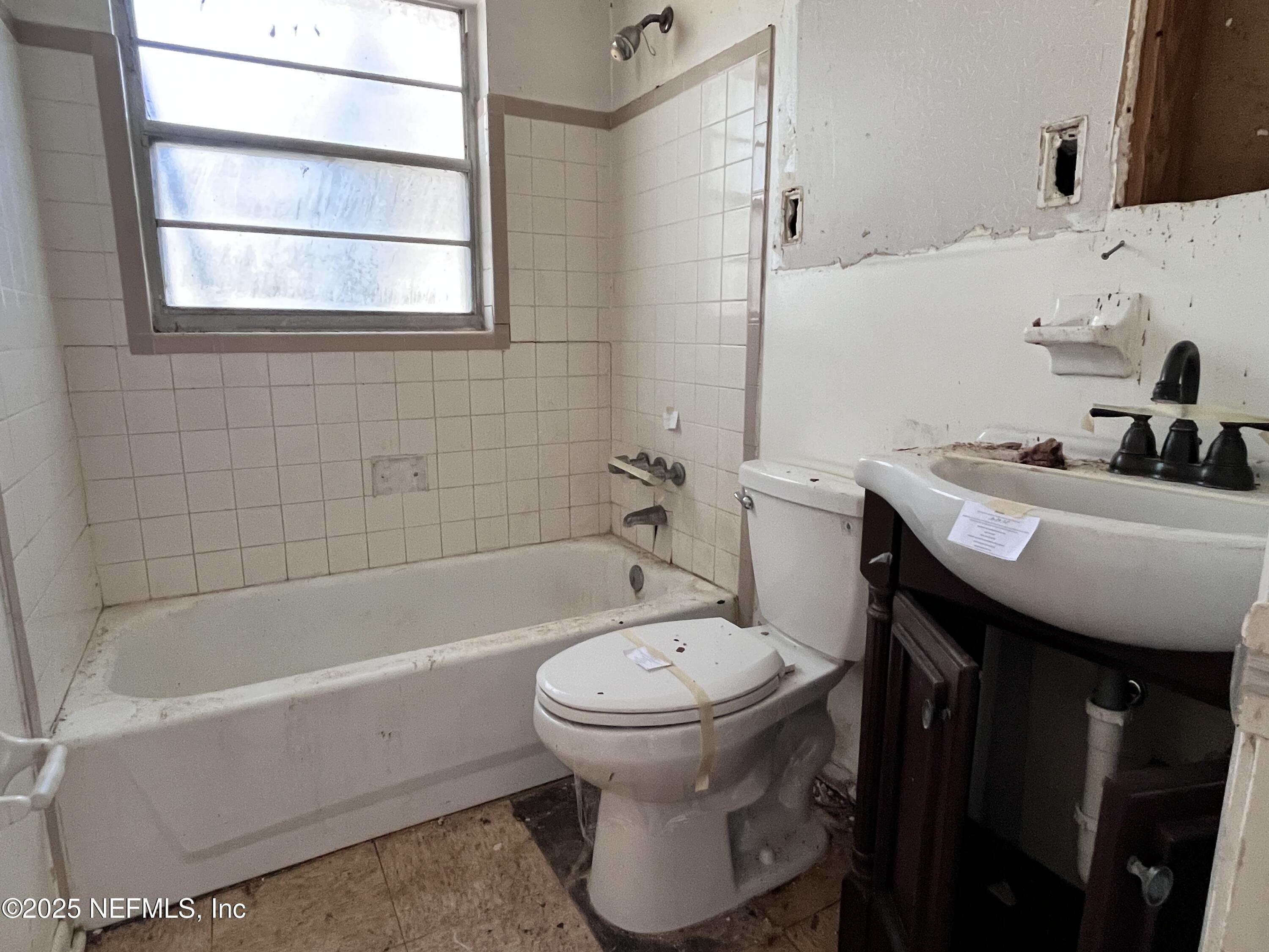 2833 Huffman Boulevard Jacksonville, FL 32246 - Photo 8 of 13 a bathroom with a sink a toilet and bathtub