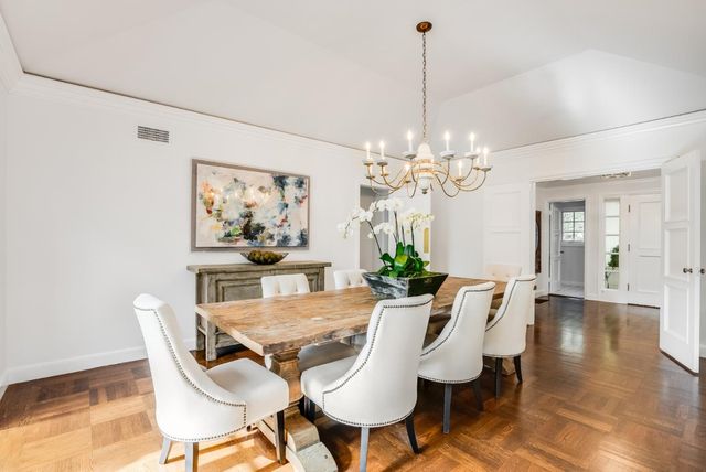 a view of a dining room with furniture a chandelier and wooden floor