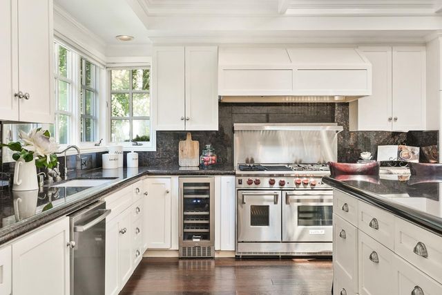 a kitchen with stainless steel appliances white cabinets and a stove top oven