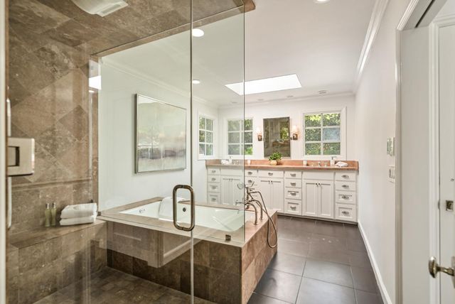 a large bathroom with a double vanity sink a mirror and a bathtub