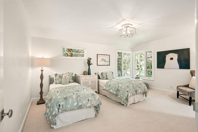 a spacious bedroom with two beds and a window