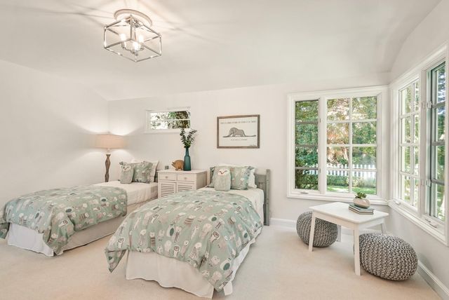 a bedroom with two beds and a large window