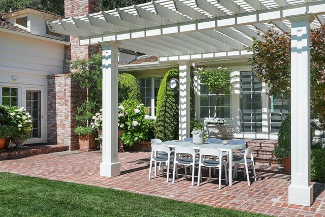 a view of a patio with table and chairs potted plants
