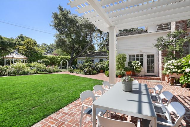 a view of a house with backyard sitting area and garden