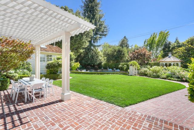 a view of a patio with a table chairs and a yard