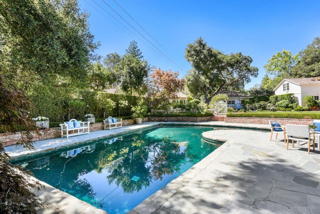 a view of swimming pool with outdoor seating and lake in the background