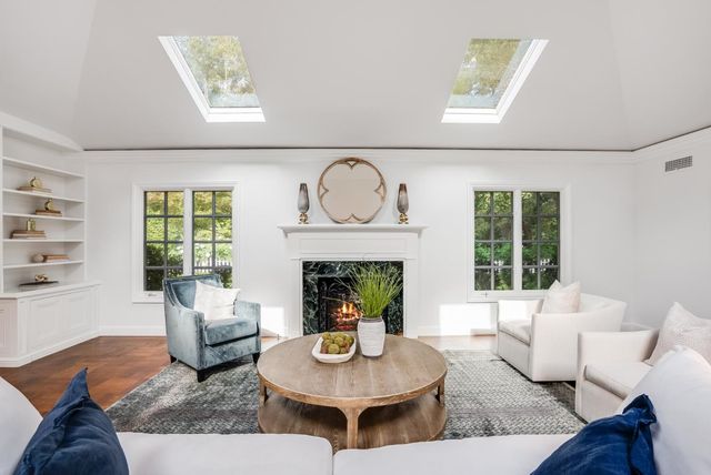 a living room with furniture a fireplace and a large window