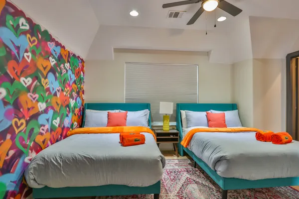 a bedroom with two beds and curtain