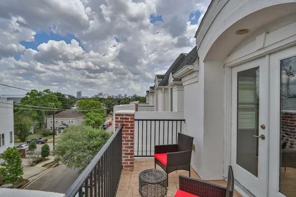 a balcony with wooden floor and outdoor seating