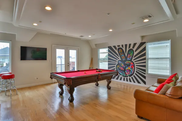 a room with furniture pool table flat screen tv and windows