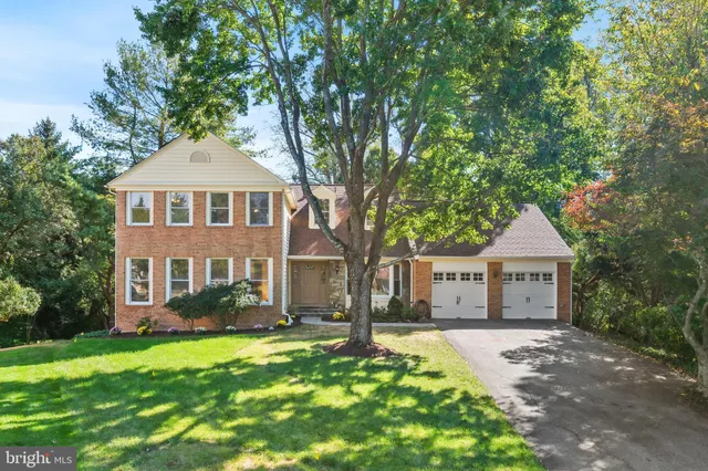 a front view of a house with a yard and trees