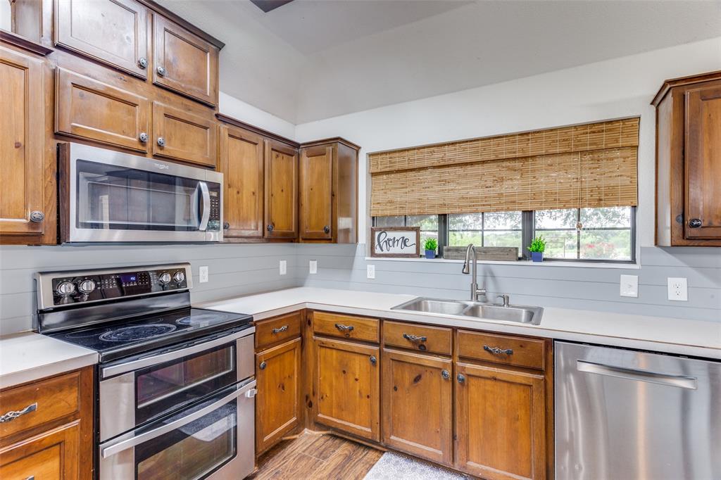 950 Johnson Bend Road Weatherford, TX 76088 - Photo 13 of 40 a kitchen with stainless steel appliances a sink cabinets and a window