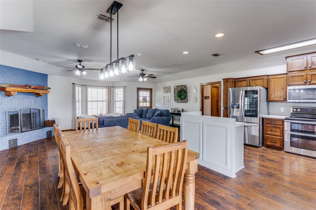 950 Johnson Bend Road Weatherford, TX 76088 - Photo 16 of 40 a view of a dining room and livingroom with furniture wooden floor a chandelier