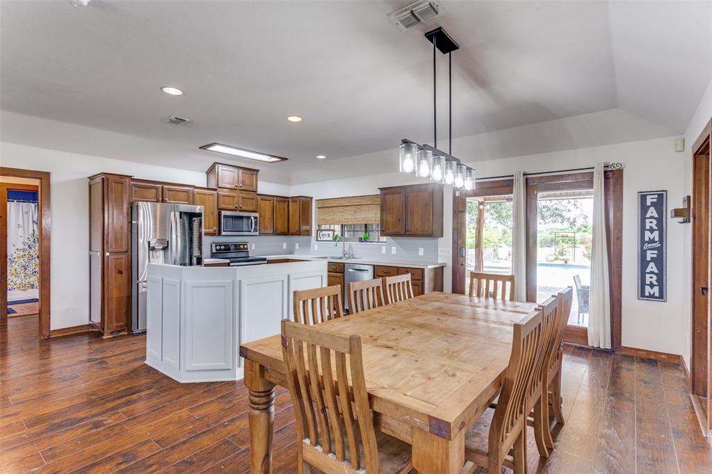 950 Johnson Bend Road Weatherford, TX 76088 - Photo 17 of 40 a dining room with furniture a chandelier and wooden floor