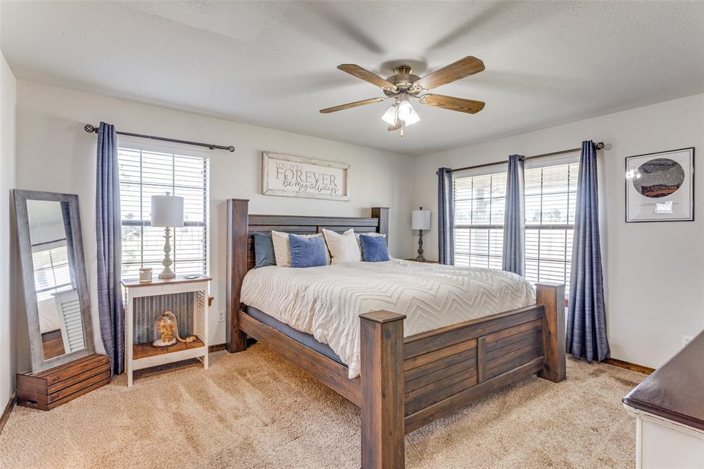 950 Johnson Bend Road Weatherford, TX 76088 - Photo 18 of 40 a bedroom with a large bed and a chandelier