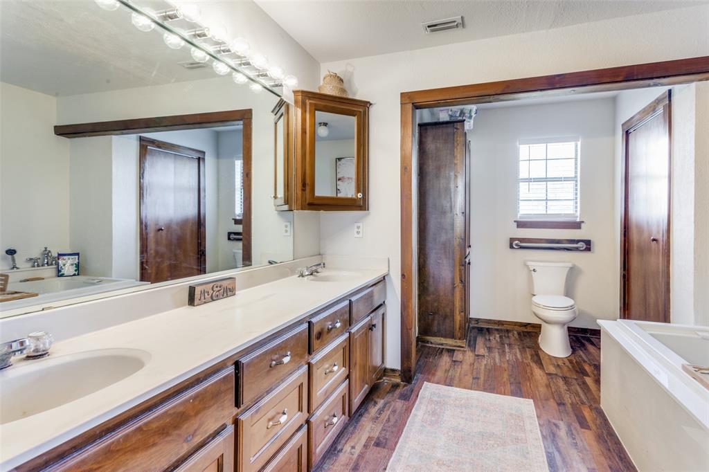 950 Johnson Bend Road Weatherford, TX 76088 - Photo 19 of 40 a spacious bathroom with a double vanity sink a large mirror and a bathtub