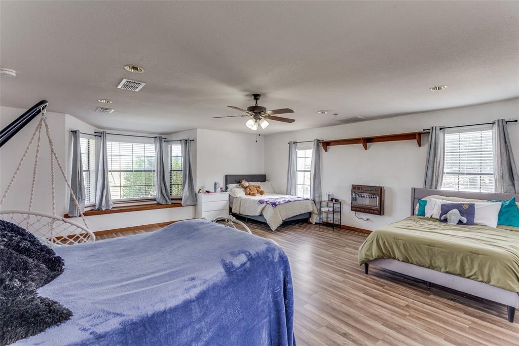 950 Johnson Bend Road Weatherford, TX 76088 - Photo 24 of 40 a spacious bedroom with a bed couch and a large window