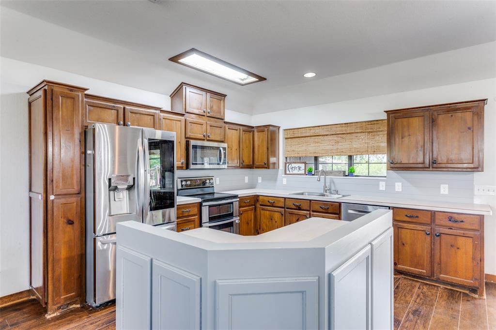 950 Johnson Bend Road Weatherford, TX 76088 - Photo 10 of 40 a kitchen with stainless steel appliances granite countertop a refrigerator a sink a stove and cabinets