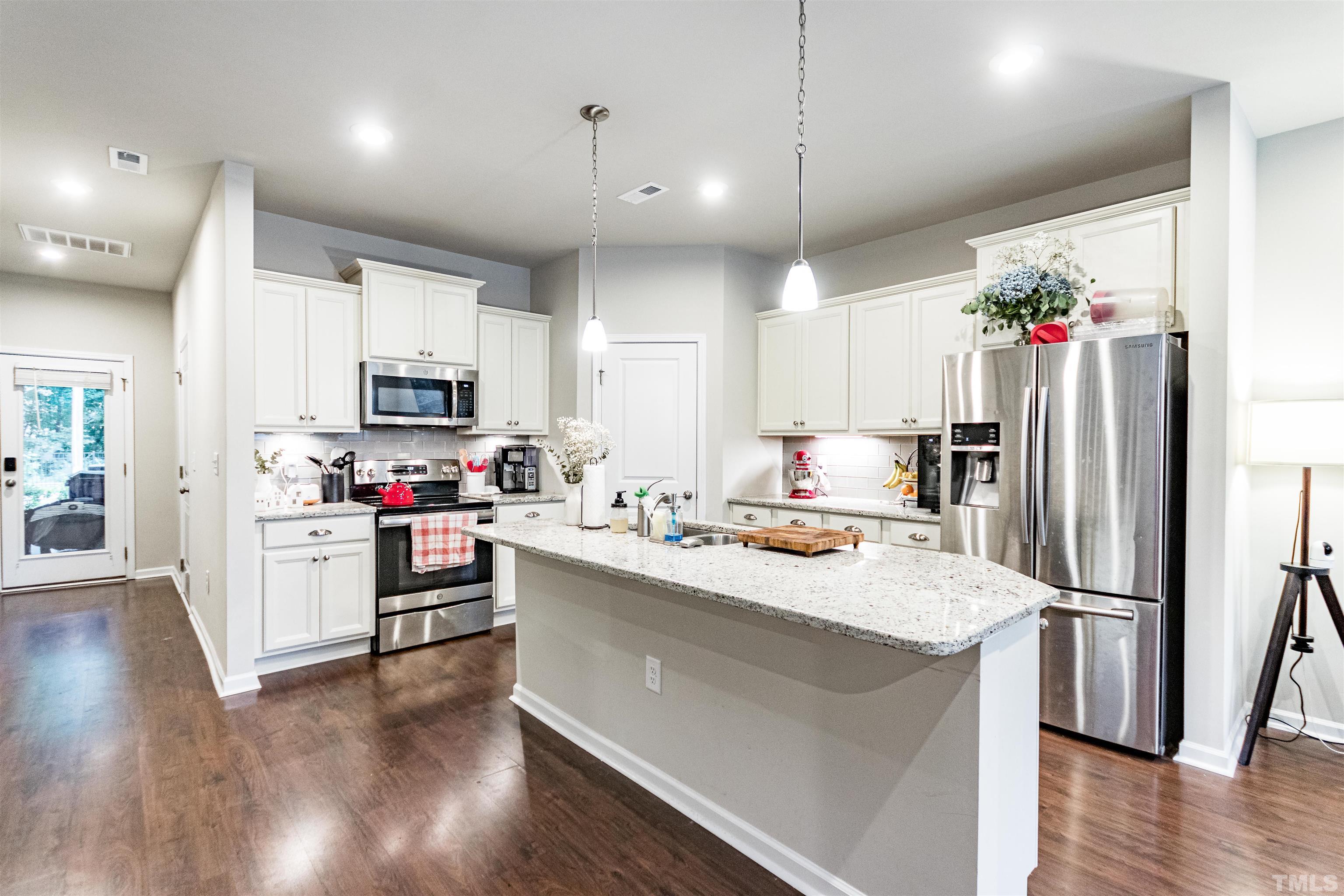 3702 Buffaloe Road Raleigh, NC 27604 - Photo 3 of 13 a kitchen with kitchen island a white counter top space cabinets and stainless steel appliances