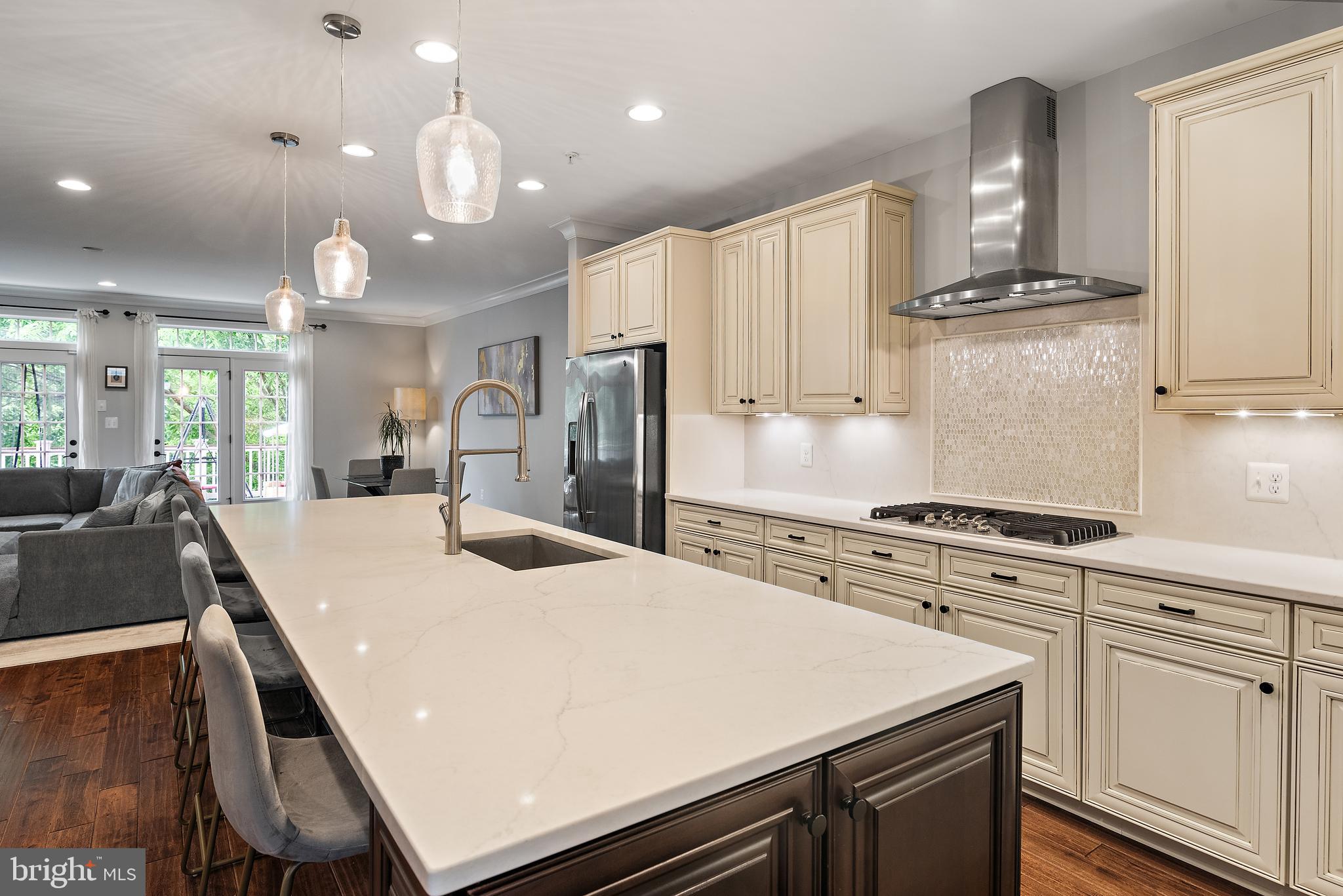 138 Merrimack Way Arnold, MD 21012 - Photo 10 of 50 a kitchen with kitchen island a stove a sink a refrigerator and chairs
